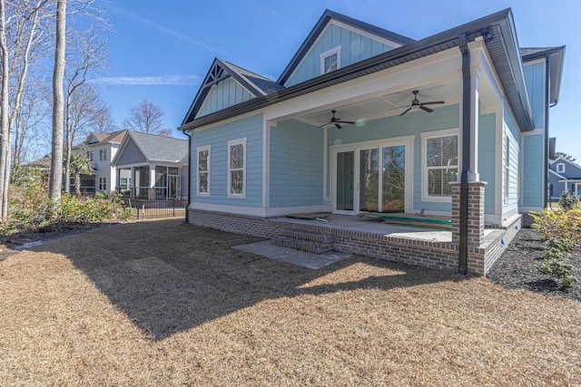 back of property featuring ceiling fan, fence, board and batten siding, and a patio