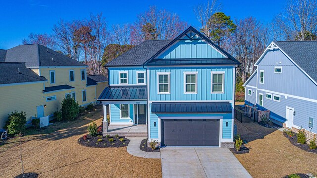 view of front of property with board and batten siding, a standing seam roof, covered porch, and driveway