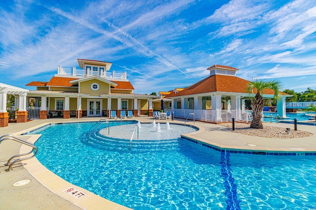 community pool with a patio, french doors, and fence