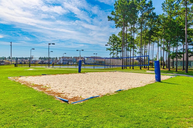 view of home's community with volleyball court and a lawn