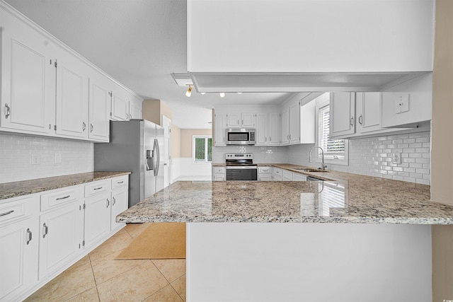 kitchen featuring appliances with stainless steel finishes, kitchen peninsula, and backsplash