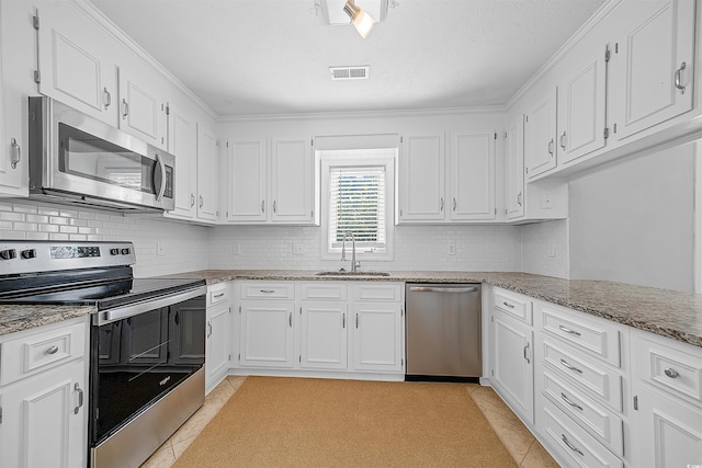 kitchen featuring sink, light tile flooring, white cabinetry, and stainless steel appliances