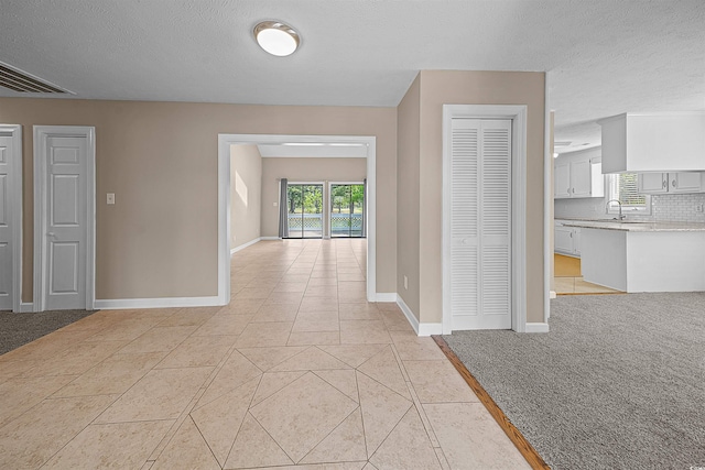 unfurnished room featuring light tile floors and a textured ceiling