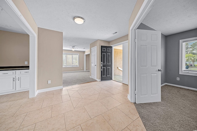 tiled spare room with ceiling fan and a textured ceiling