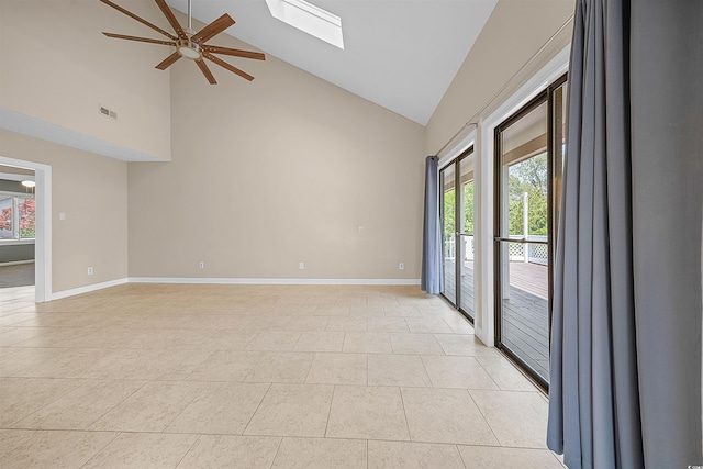 tiled spare room featuring a skylight, a healthy amount of sunlight, ceiling fan, and high vaulted ceiling