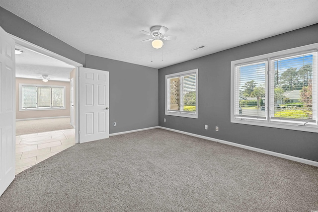 tiled empty room featuring ceiling fan and a textured ceiling