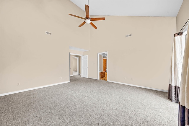 empty room with high vaulted ceiling, ceiling fan, and carpet floors