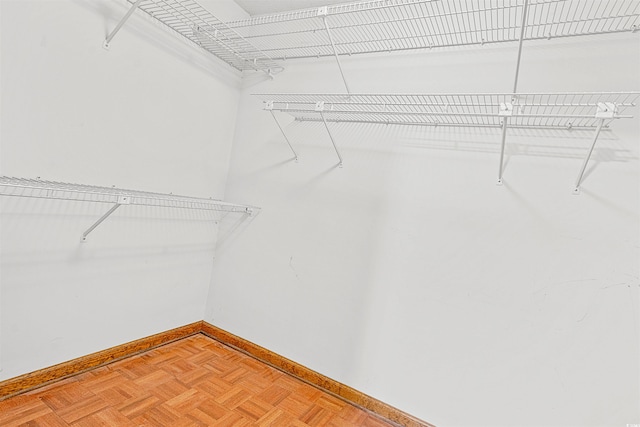 walk in closet featuring parquet floors