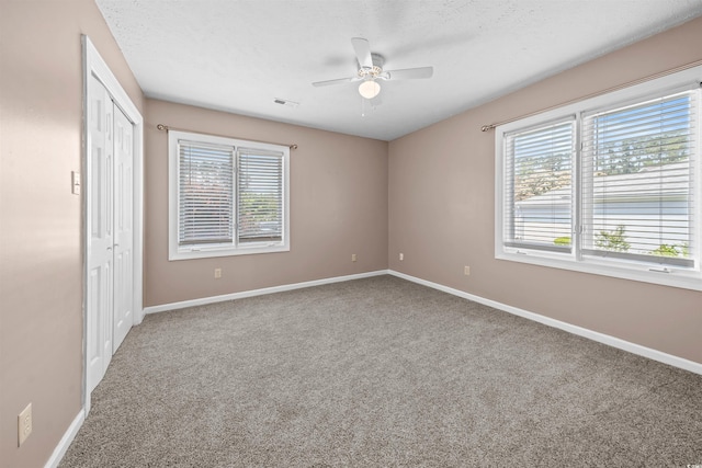 spare room featuring ceiling fan and carpet floors