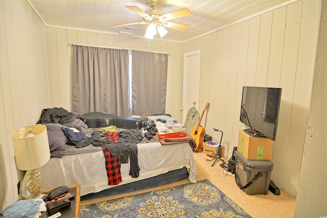 carpeted bedroom with ornamental molding and ceiling fan