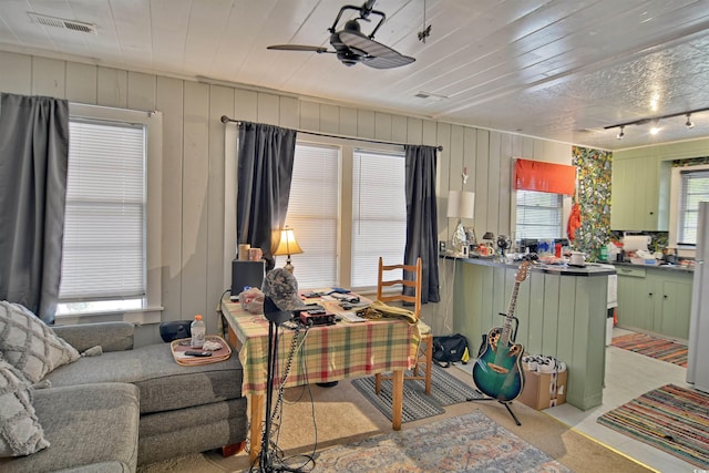 carpeted living room featuring ceiling fan and track lighting