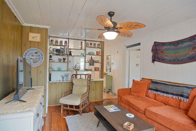 living room featuring wooden walls, ceiling fan, and hardwood / wood-style flooring