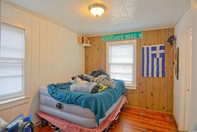 bedroom featuring wood walls and dark hardwood / wood-style flooring