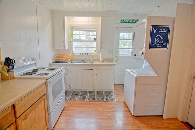 kitchen with white cabinets, sink, white electric range, light hardwood / wood-style floors, and stacked washer and dryer