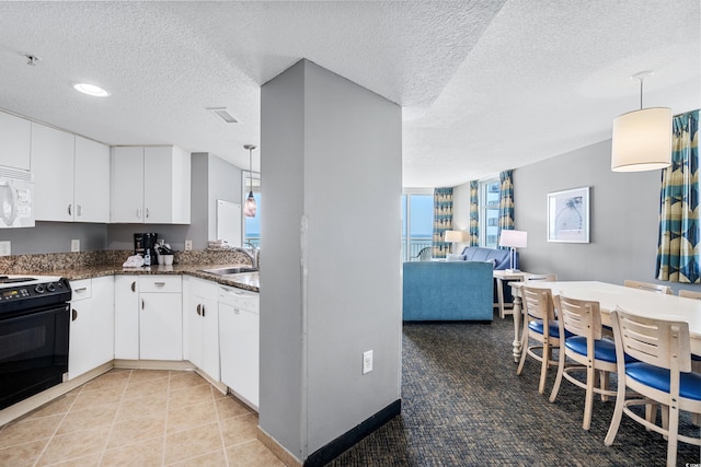 kitchen with a textured ceiling, white cabinets, white appliances, hanging light fixtures, and tile floors