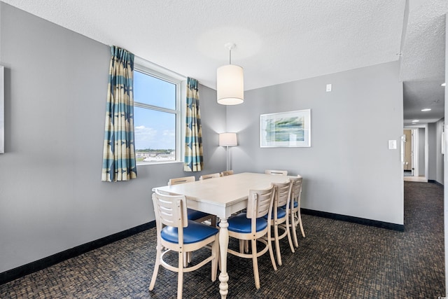 carpeted dining room featuring a textured ceiling