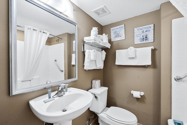 bathroom featuring sink, toilet, and a textured ceiling