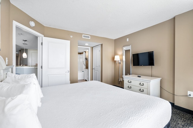 bedroom featuring ensuite bath, a textured ceiling, and a closet