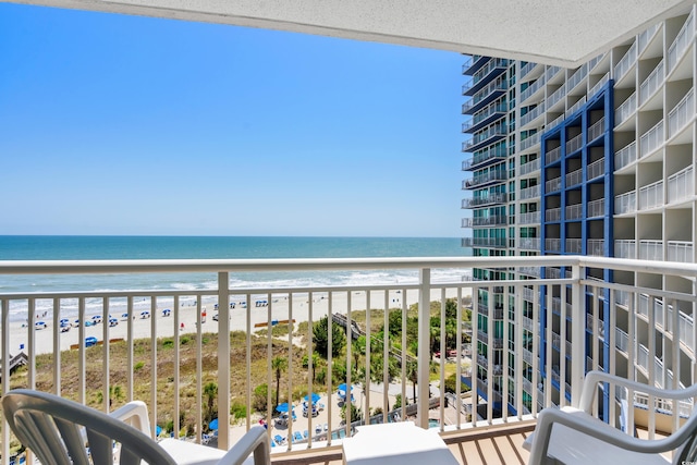 balcony featuring a view of the beach and a water view