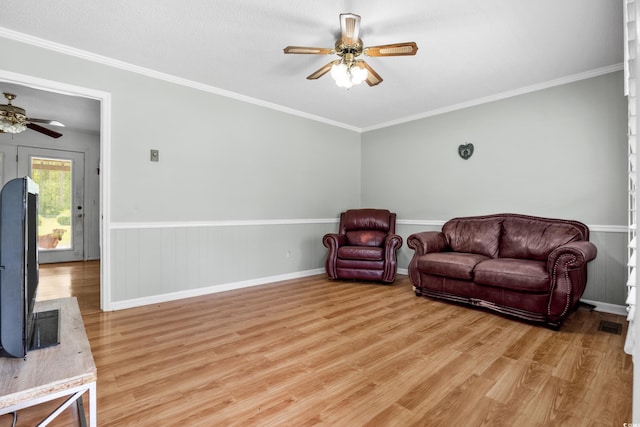 living area with ceiling fan, crown molding, and light wood-type flooring