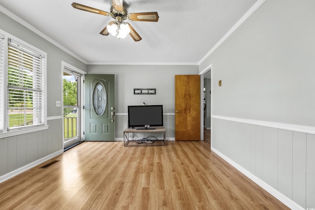 entrance foyer with crown molding, ceiling fan, a textured ceiling, and light wood-type flooring