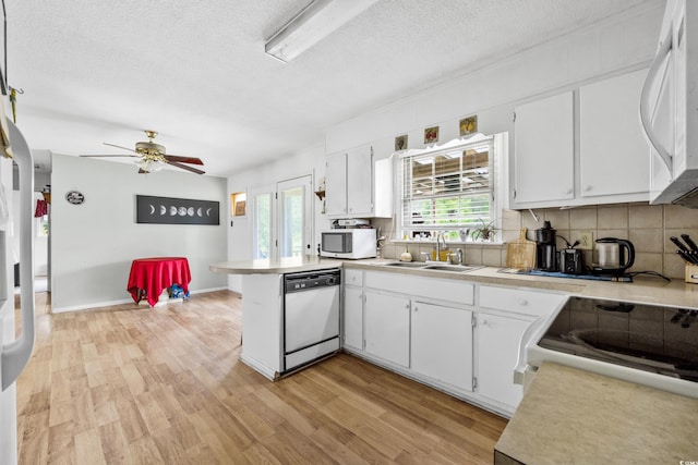 kitchen with white appliances, light wood-type flooring, white cabinetry, tasteful backsplash, and ceiling fan