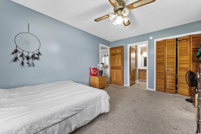 carpeted bedroom featuring ensuite bath, ceiling fan, and a closet