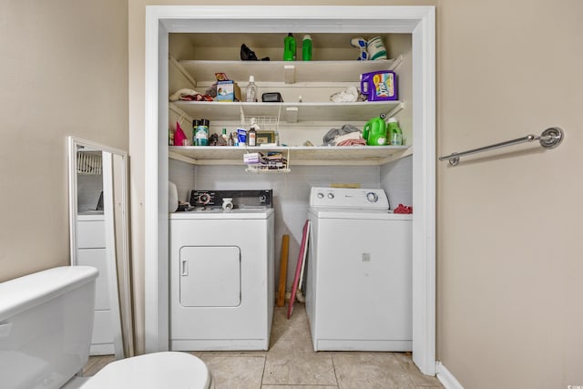 laundry room featuring light tile floors and washing machine and clothes dryer