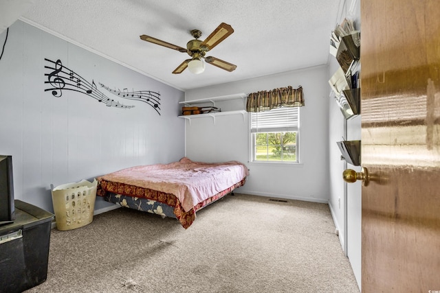 carpeted bedroom with crown molding, ceiling fan, and a textured ceiling