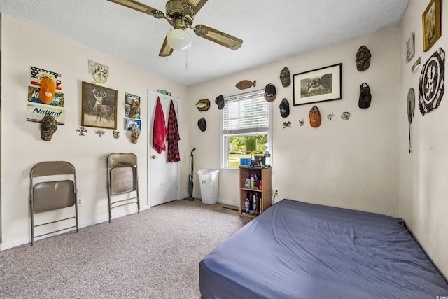 carpeted bedroom featuring a textured ceiling and ceiling fan