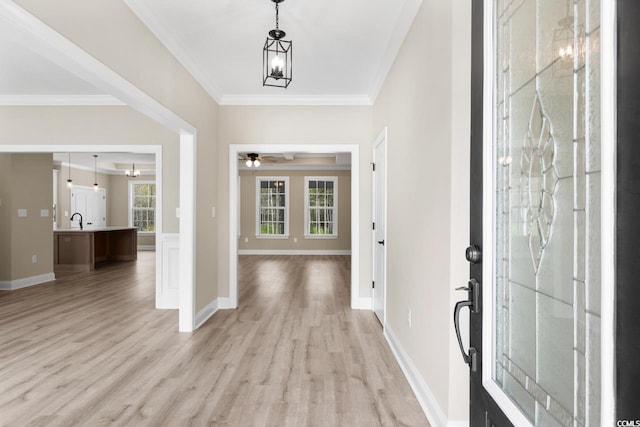 foyer entrance with ornamental molding, light hardwood / wood-style flooring, ceiling fan, and sink