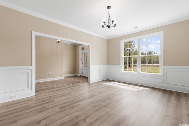 unfurnished room with ornamental molding, wood-type flooring, and a chandelier