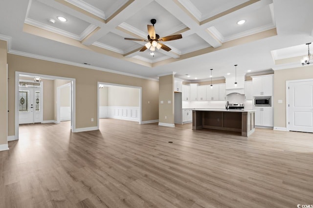 unfurnished living room with ornamental molding, ceiling fan with notable chandelier, light wood-type flooring, and coffered ceiling