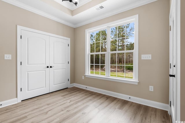 unfurnished bedroom featuring ornamental molding, light hardwood / wood-style flooring, and multiple windows