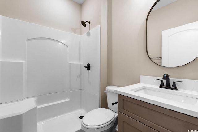 bathroom featuring walk in shower, toilet, and vanity