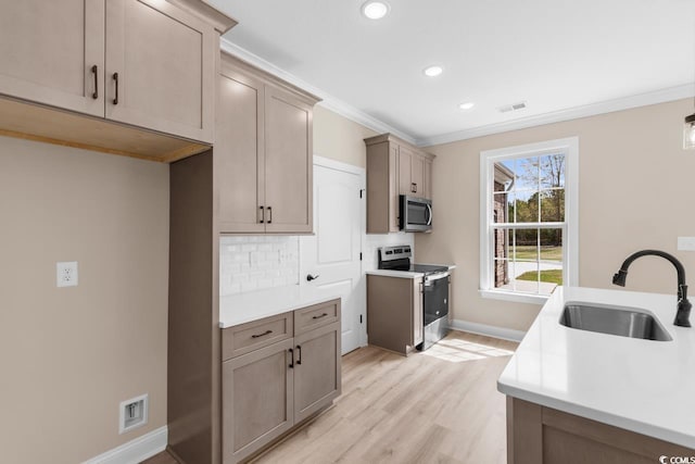 kitchen featuring sink, backsplash, crown molding, stainless steel appliances, and light hardwood / wood-style flooring