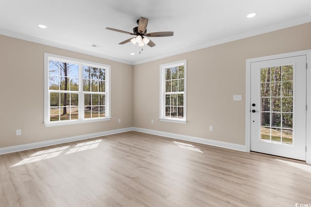 spare room featuring a wealth of natural light, crown molding, light hardwood / wood-style floors, and ceiling fan