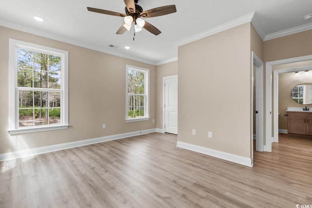 empty room with a wealth of natural light, crown molding, light hardwood / wood-style floors, and ceiling fan