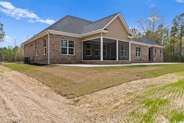 back of house featuring central AC unit and a lawn