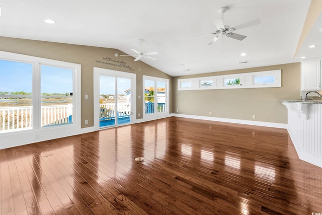 unfurnished living room with ceiling fan, dark hardwood / wood-style flooring, lofted ceiling, and sink