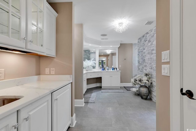 bathroom featuring tile patterned flooring, vanity, and an inviting chandelier