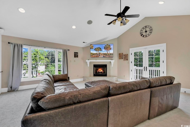 carpeted living room with a premium fireplace, ceiling fan, high vaulted ceiling, and french doors