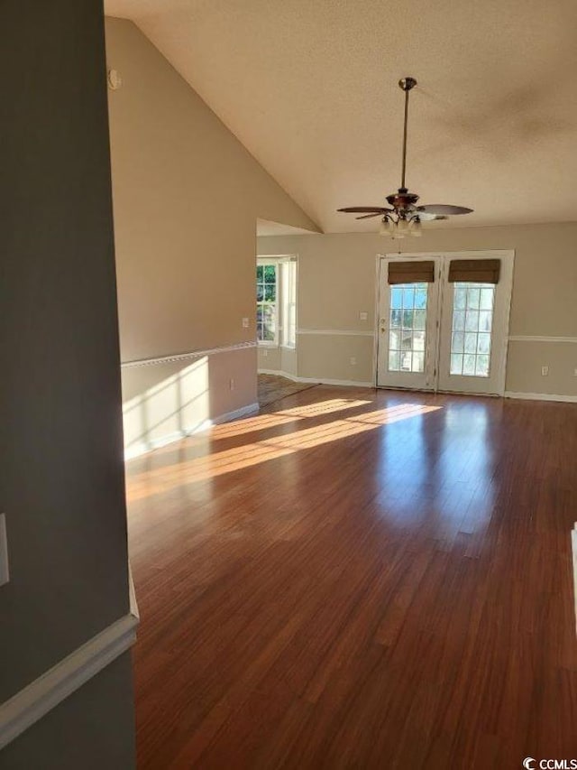 unfurnished living room featuring lofted ceiling, wood-type flooring, and ceiling fan