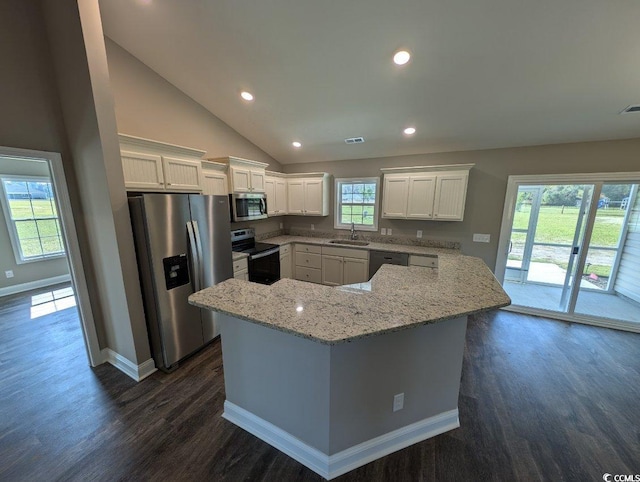 kitchen featuring light stone counters, appliances with stainless steel finishes, dark wood-style floors, white cabinetry, and a sink