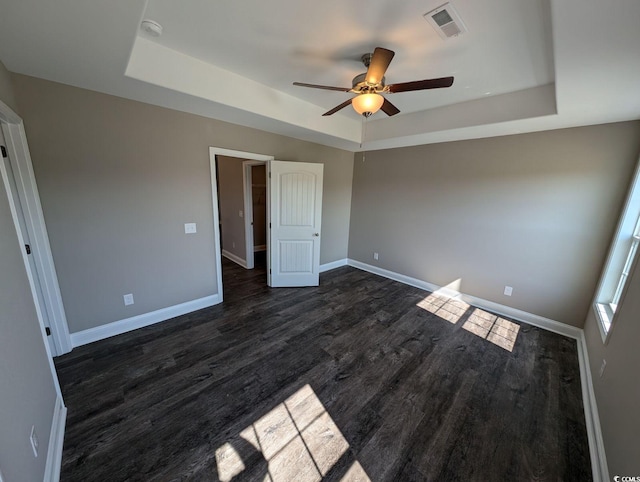 unfurnished bedroom featuring visible vents, baseboards, and a tray ceiling