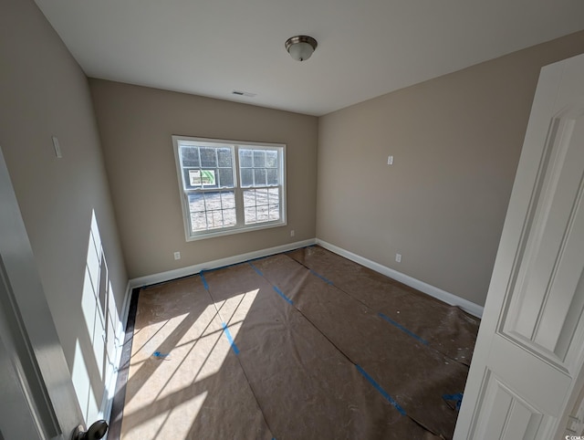 unfurnished room with visible vents and baseboards