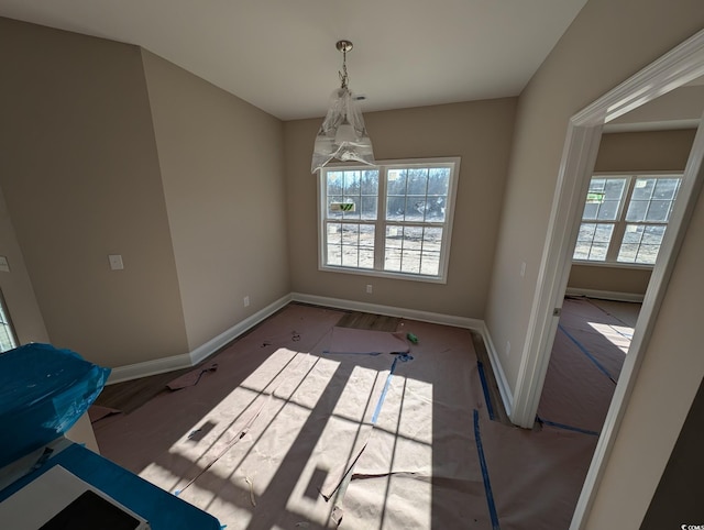 unfurnished dining area featuring an inviting chandelier