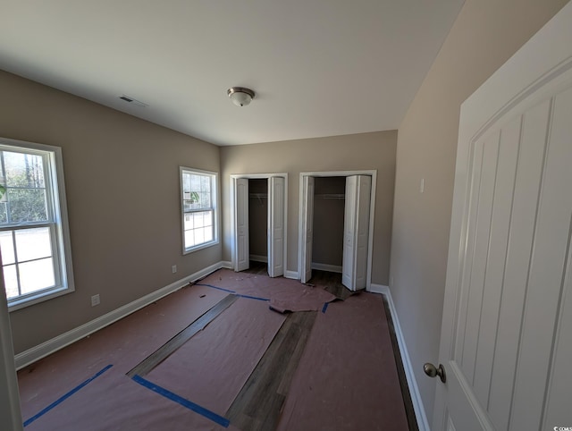 unfurnished bedroom featuring two closets