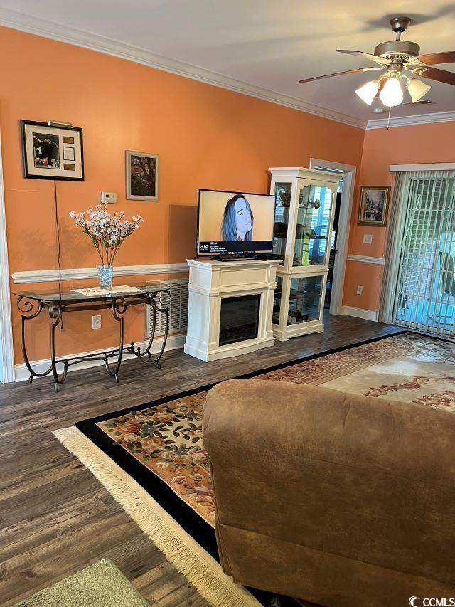 living room with hardwood / wood-style floors, ceiling fan, and crown molding