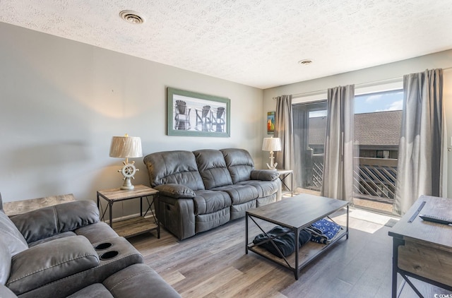 living room with hardwood / wood-style flooring and a textured ceiling